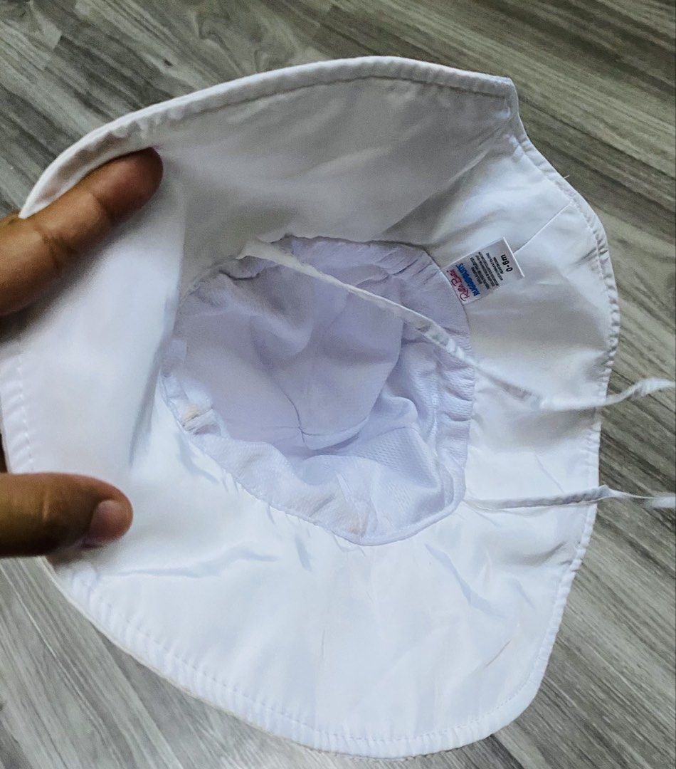 RuggedButts White Baby Sun Hat (Category: Babies & Kids Fashion) located in Caloocan City. Submitted by lovemyclothes21 (Listing ID 1470757533, Image 2). Description: - Brand: RuggedButts - Size: 0-6 Months - Color: Plain white (goes with any outfit) - Material: 100% polyester shell and lining with breathable mesh - Features: Wide brim for sun protection and a secure chin strap for windy days - Condition: Brand new / Excellent.