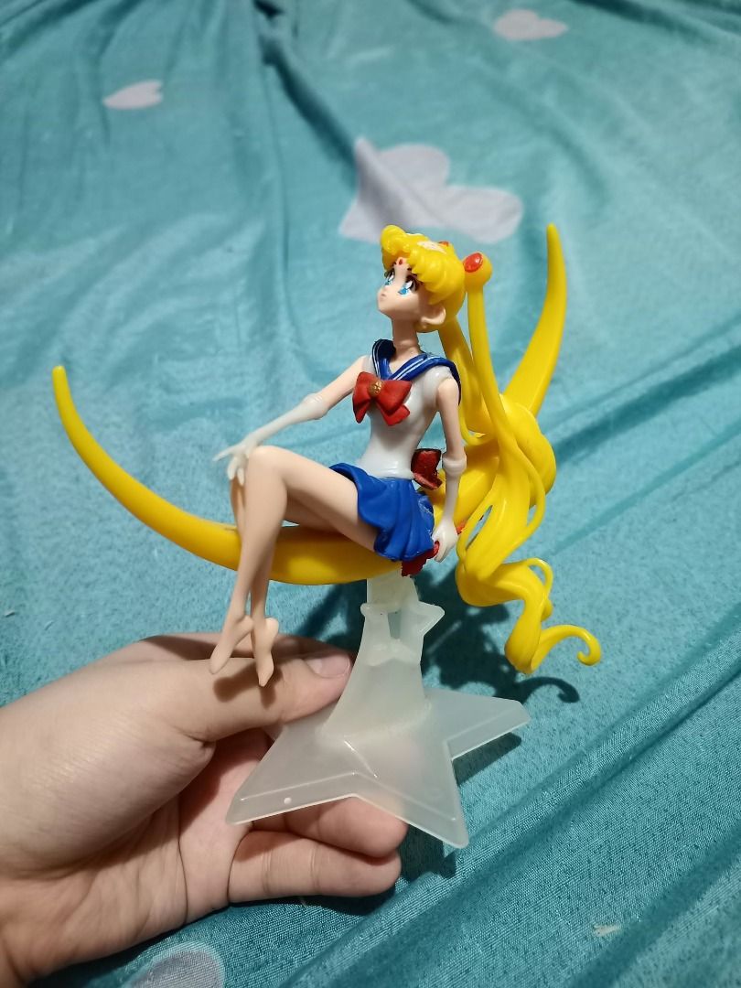 Sailor Moon Sitting on Crescent Moon Figure (Category: Figurines & Statues) located in Manila. Submitted by rzeecola (Listing ID 1470884468, Image 3). Description: Sailor Moon Crescent Moon Figure A palm-sized Sailor Moon figure featuring her sitting gracefully on a yellow crescent moon Details: - Intricate sculpt with classic Sailor Moon details, including blonde buns, blue-and-white uniform, and red bow - Palm-sized, perfect for display or as a