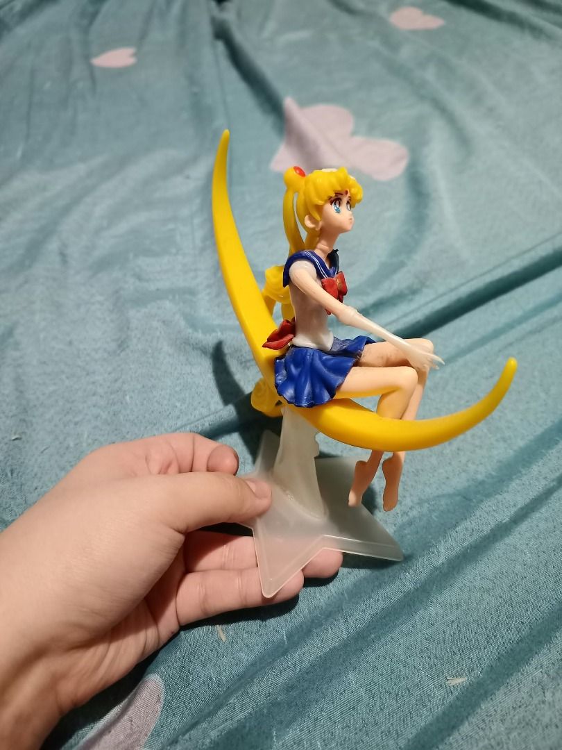 Sailor Moon Sitting on Crescent Moon Figure (Category: Figurines & Statues) located in Manila. Submitted by rzeecola (Listing ID 1470884468, Image 2). Description: Sailor Moon Crescent Moon Figure A palm-sized Sailor Moon figure featuring her sitting gracefully on a yellow crescent moon Details: - Intricate sculpt with classic Sailor Moon details, including blonde buns, blue-and-white uniform, and red bow - Palm-sized, perfect for display or as a