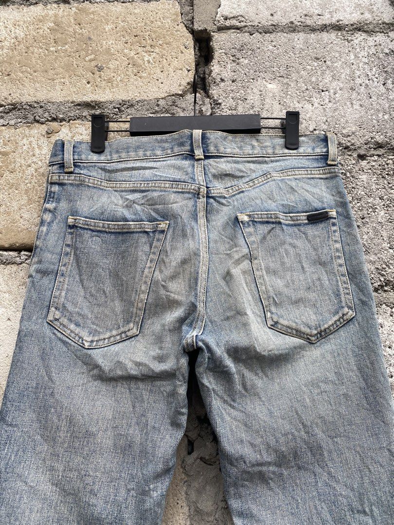 Saint Laurent Paris Wash Jeans (Category: Jeans) located in Candaba. Submitted by dejesus.bench17 (Listing ID 1470931578, Image 3). Description: - Brand: Saint Laurent Paris - Authentic Legit - Wash: Light wash with distressed vintage finish - Fit: Slim leg cut for everyday wear - Closure: Button fly with branded hardware and engraved zipper pull - Pockets: Classic five-pocket layout with back pocket tag detail - Issue cut wash tag - Condition: E