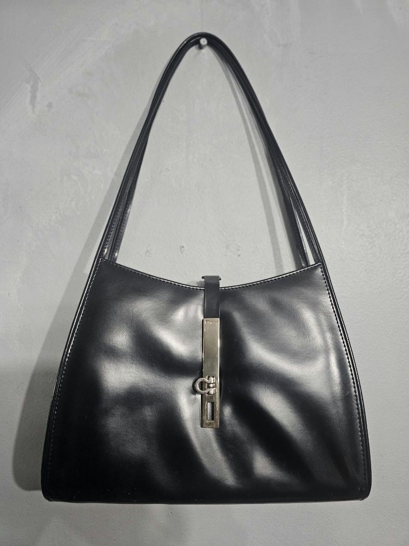 Salvatore Ferragamo Black Leather Shoulder Bag (Category: Luxury Bags & Wallets) located in Makati City. Submitted by idaevangelista (Listing ID 1470885457, Image 1). Description: - Brand: Salvatore Ferragamo - Color: Solid black - Material: Premium leather - Design: Structured trapezoid shape with clean silhouette - Straps: Long double straps for comfortable shoulder wear - Hardware: Metal closure on front vertical tab - Capacity: Spacious enoug