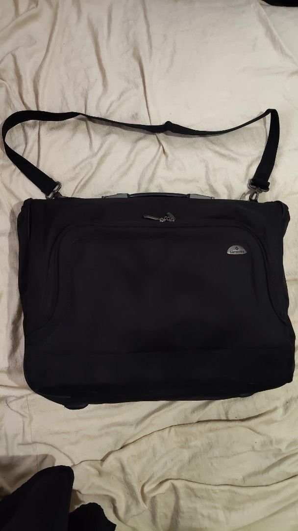 Samsonite Black Travel Garment Bag with Shoulder Strap (Category: Briefcases) located in Cebu City. Submitted by lumaynojes00490 (Listing ID 1470828614, Image 1). Description: - Brand: Samsonite - Color: Black - Durable fabric construction - Sturdy top handle & adjustable shoulder strap - Multiple zippered exterior pockets for easy organization - Protective feet on the bottom edge - Solid build, ready for your next trip.