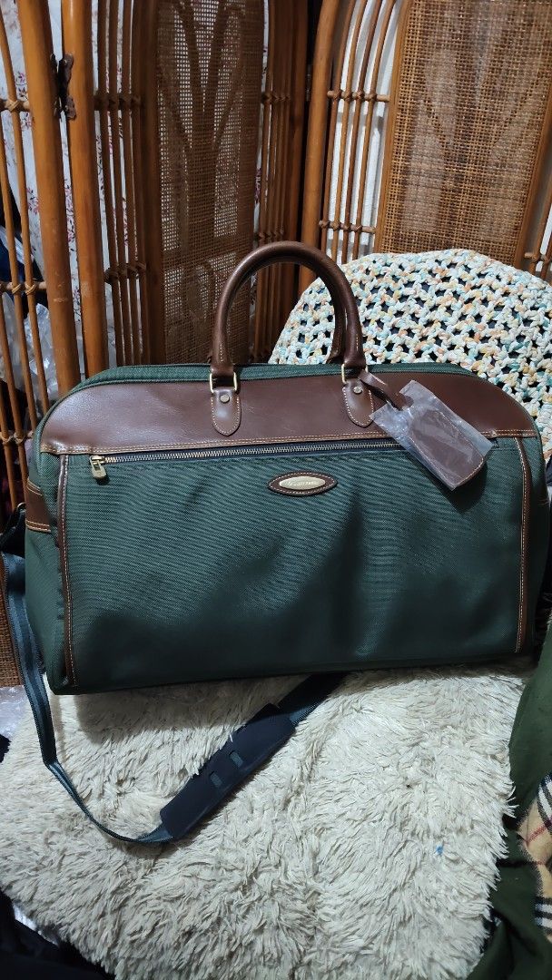 Samsonite Green and Brown Travel Duffel Bag (Category: Sling Bags) located in Cebu City. Submitted by lumaynojes00490 (Listing ID 1470830003, Image 2). Description: - Brand: Samsonite - Color: Green fabric with brown leather trim - Hardware: Gold-tone - Features: Zippered front pocket, sturdy structure, clean canvas body - Straps: Top carry handles and adjustable padded shoulder strap - Extras: Luggage tag still wrapped in plastic attached to han
