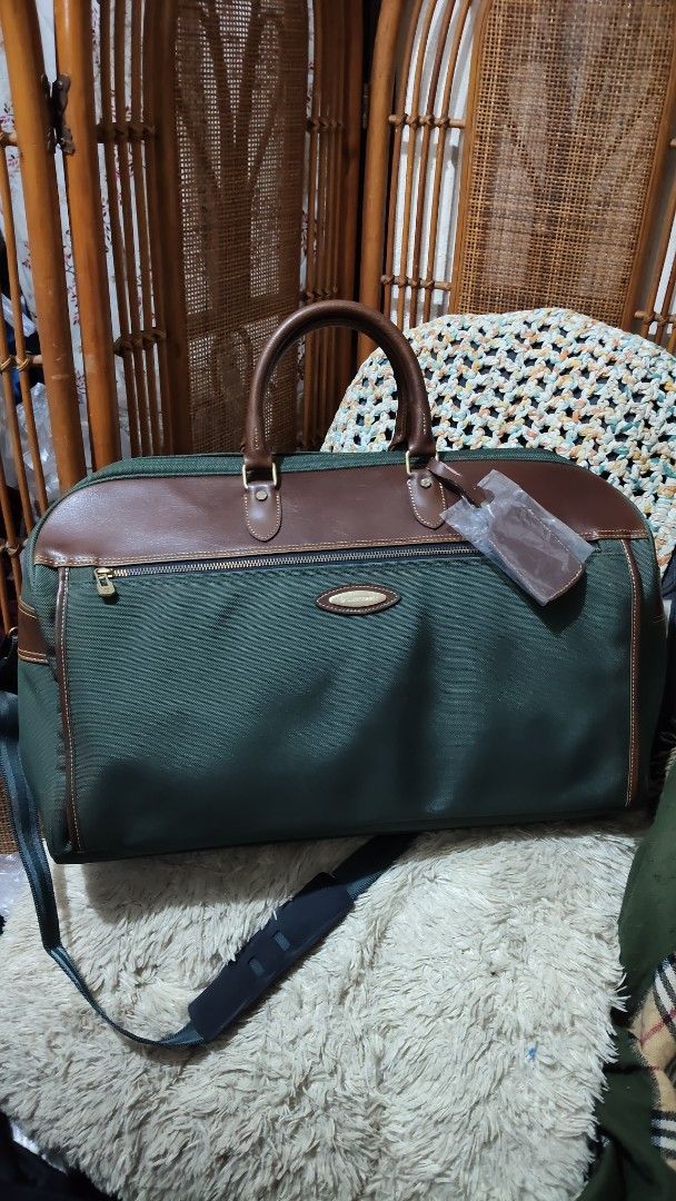 Samsonite Green and Brown Travel Duffel Bag (Category: Sling Bags) located in Cebu City. Submitted by lumaynojes00490 (Listing ID 1470830003, Image 3). Description: - Brand: Samsonite - Color: Green fabric with brown leather trim - Hardware: Gold-tone - Features: Zippered front pocket, sturdy structure, clean canvas body - Straps: Top carry handles and adjustable padded shoulder strap - Extras: Luggage tag still wrapped in plastic attached to han