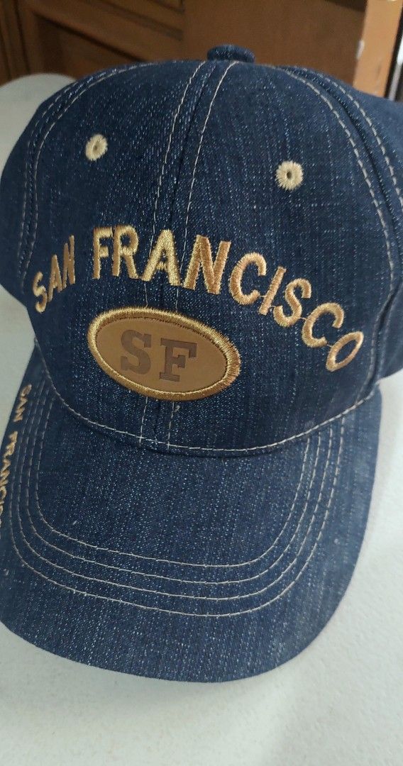 San Francisco Denim Baseball Cap (Category: Caps & Hats) located in Baguio. Submitted by ayra1523 (Listing ID 1470768707, Image 1). Description: - Brand: Lanza U.S.A. - Material: Dark denim with contrast stitching - Design: San Francisco embroidery on front and brim - Detail: Oval leather patch with stamped SF logo - Fit: Adjustable strap at the back for a custom fit - Condition: Structured crown with clean white interior lining and original bran