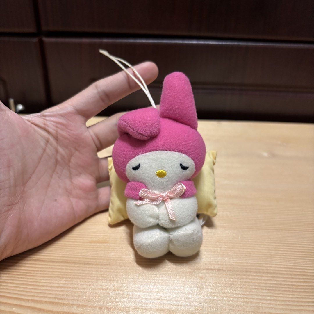 Sanrio My Melody Sleeping Plush Keychain (Category: Plushies & Soft Toys) located in Manila. Submitted by nero.ph (Listing ID 1470823191, Image 1). Description: - Authentic Sanrio My Melody plush mascot hanging charm - Features My Melody in a pink hood and white body resting on a tiny yellow pillow with a pink bow - Equipped with a white hanging loop string for bags, keys, or lanyards - Official vintage tag reads Sanrio copyright 1976, 2000, Toky