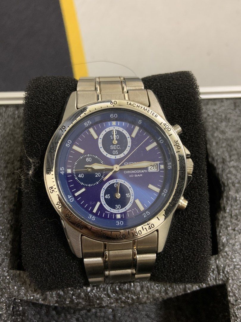 Seiko Chronograph 10 Bar Blue Dial Watch (Category: Men's Watches) located in Manila. Submitted by relokado (Listing ID 1470869736, Image 1). Description: - Brand: Seiko Chronograph - Dial: Striking blue sunburst dial with date window at 3 o'clock - Case & Bracelet: Stainless steel with standard deployment clasp - Features: Tachymeter bezel, 3 sub-dials (chronograph seconds, minutes, 1/20th seconds) - Water Resistance: Up to 10 bar - Condition: N