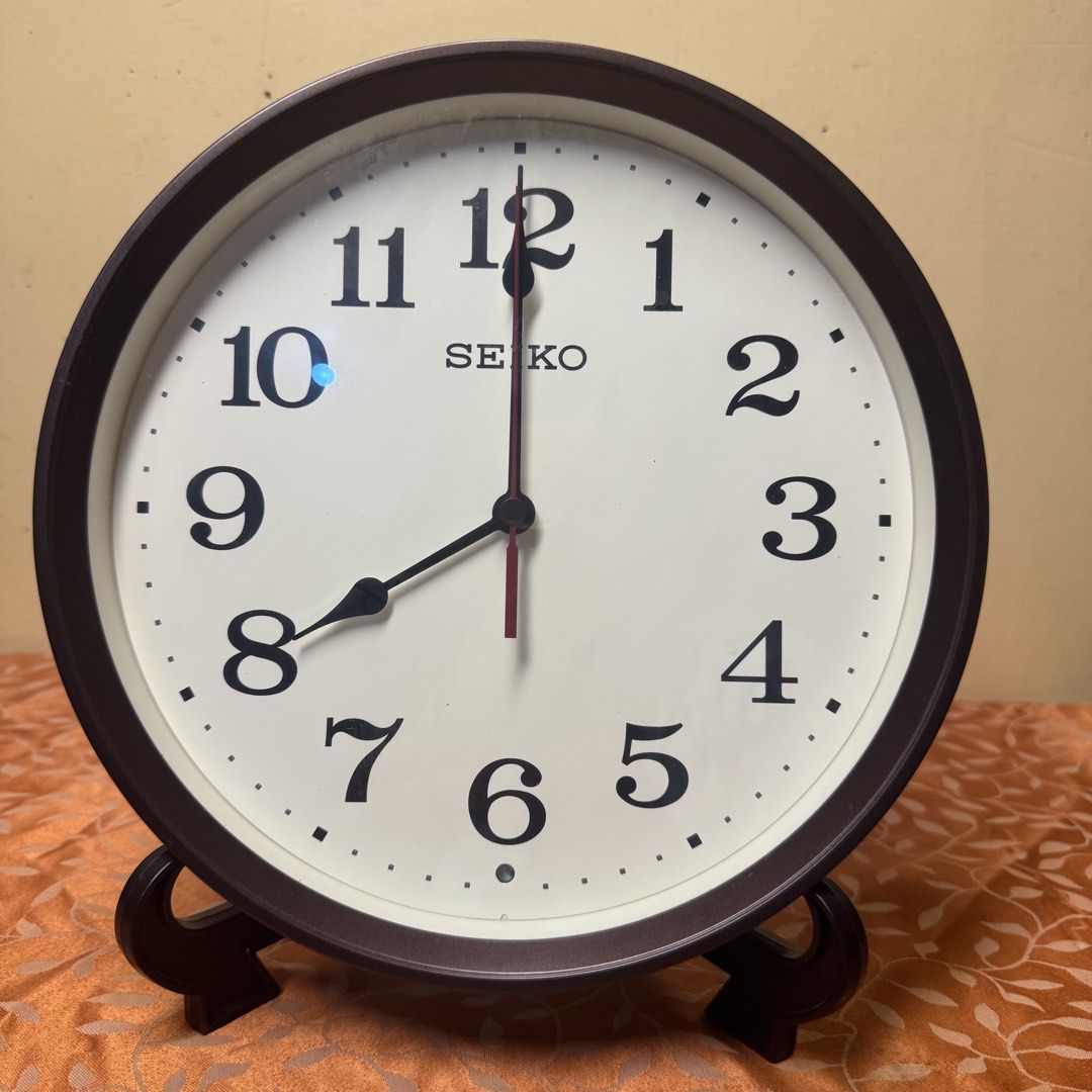 SEIKO Radio-Controlled Wall Clock (Model: KX223B) (Category: Clocks) located in Pasig City. Submitted by msjazzylad (Listing ID 1470928446, Image 1). Description: Product Overview Brand: SEIKO Model: KX223B Type: Radio-Controlled / Wave-Calibrated Quartz Wall Clock (Radio Wave / Radio Control) Design: Dark brown / wooden-tone round frame with retro classic font numbers, off-white dial, at red second hand. Dimensions: Diameter: Approx. 11 inches (