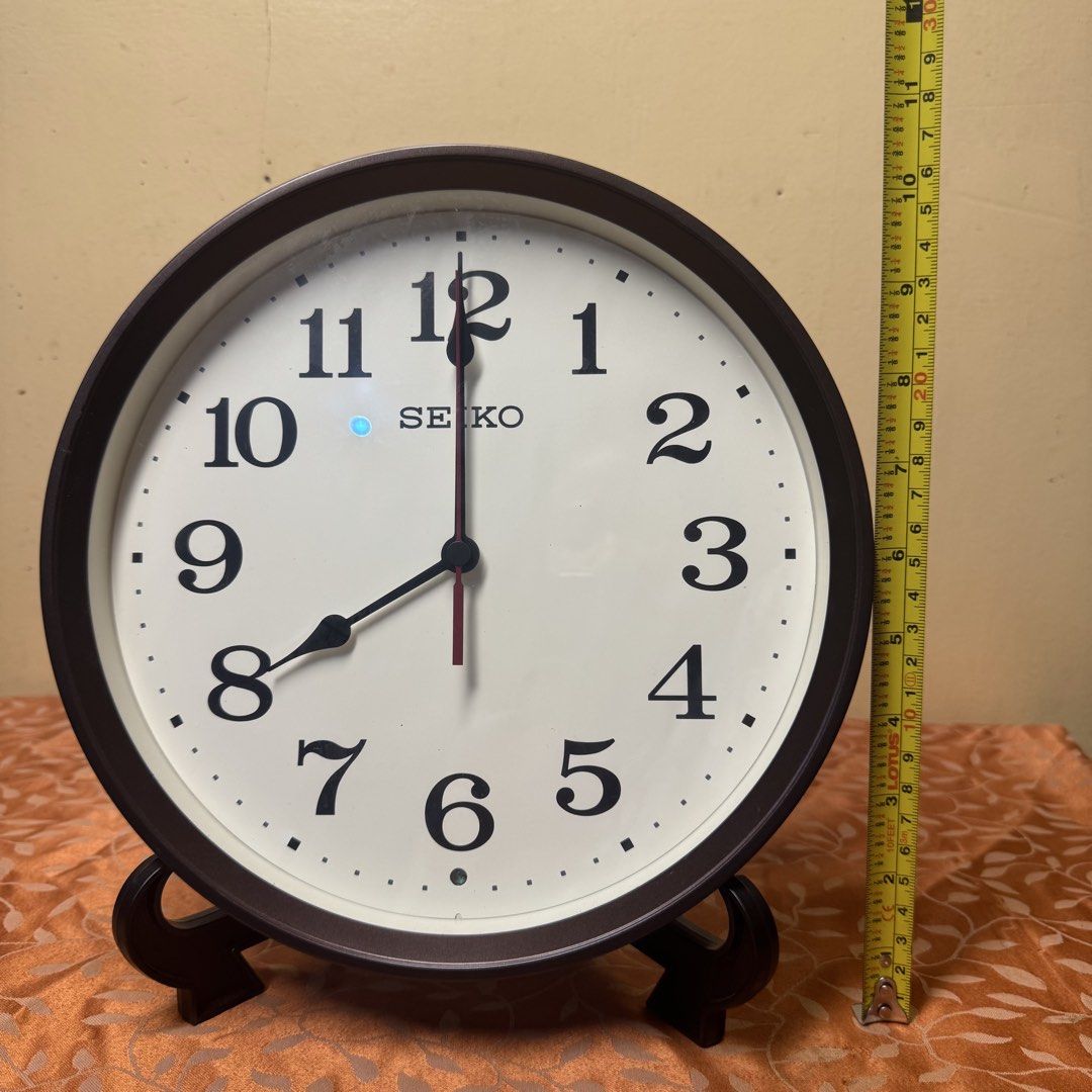 SEIKO Radio-Controlled Wall Clock (Model: KX223B) (Category: Clocks) located in Pasig City. Submitted by msjazzylad (Listing ID 1470928446, Image 2). Description: Product Overview Brand: SEIKO Model: KX223B Type: Radio-Controlled / Wave-Calibrated Quartz Wall Clock (Radio Wave / Radio Control) Design: Dark brown / wooden-tone round frame with retro classic font numbers, off-white dial, at red second hand. Dimensions: Diameter: Approx. 11 inches (