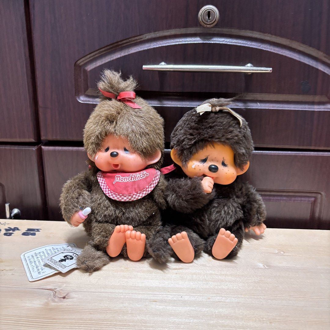 Sekiguchi Monchhichi Monkey Dolls Pair Vintage Plush (Category: Plushies & Soft Toys) located in Manila. Submitted by nero.ph (Listing ID 1470823903, Image 1). Description: 3K SET WITH MONCCHICHU PIANO (DoReMiFaSoLaTiDo) - Authentic vintage Sekiguchi Monchhichi plush doll set - Includes 2 dolls: one with a red gingham bib and pink dummy, and one with a white ribbon - Features original paper hang tags and fabric tags - Classic brown fur with vinta
