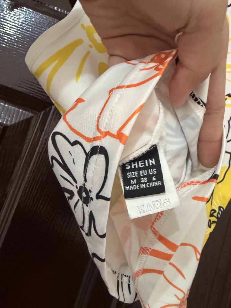 SHEIN Floral Print Crop Top Size M (Category: Sleeveless) located in Marikina City. Submitted by _bananahanaa (Listing ID 1470802083, Image 3). Description: - Brand: SHEIN - Style: Sleeveless crop top with crew neckline - Design: White base with a vibrant yellow, orange, and black floral print - Size: M (EU 38, US 6) - Fabric: Lightweight and comfortable - Perfect for: Summer wear, easy to style with high-waisted shorts, skirts, or jeans fits sma