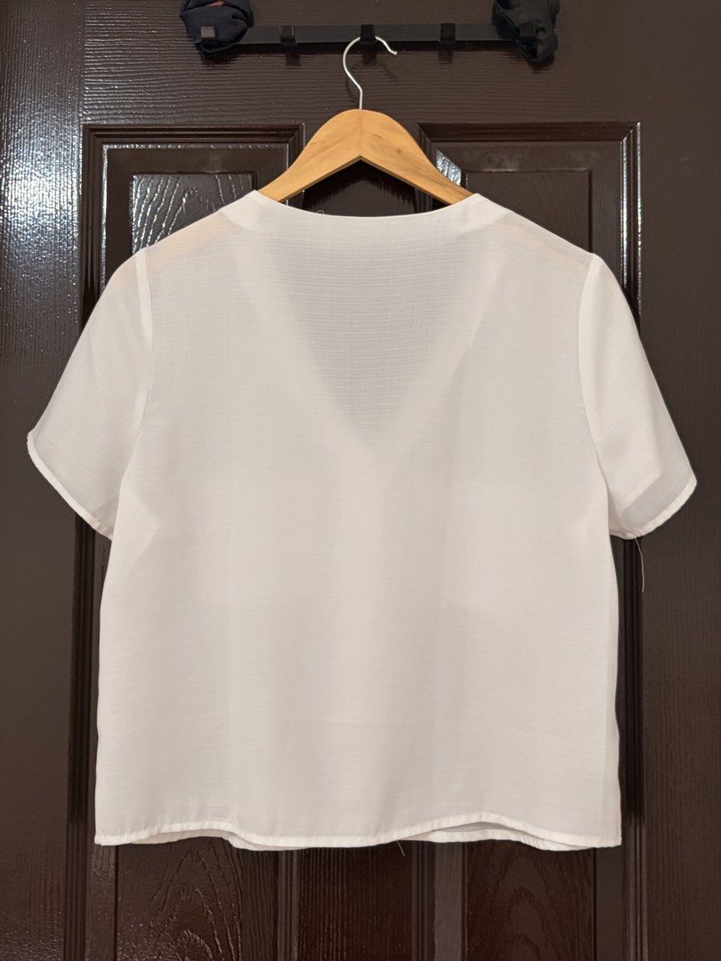 SHEIN White V-Neck Short Sleeve Button-Down Blouse (Category: Blouses) located in Marikina City. Submitted by _bananahanaa (Listing ID 1470802734, Image 2). Description: - Brand: SHEIN - Color: White - Style: V-neck button-down blouse with short sleeves - Details: Two chest pockets, stylish wooden-look front buttons - Material: Lightweight and breathable fabric - Condition: Clean, excellent, and ready to wear - Versatility: Perfect daily basic, e