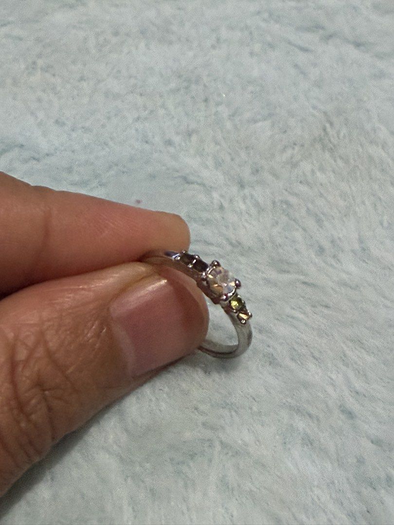 Silver multi-stone ring with central iridescent crystal but with missing crystal Size 5.5 (Category: Rings) located in Mandaue City. Submitted by chuchi152615 (Listing ID 1470916208, Image 1). Description: Issue: missing stones - Silver-tone band with a striking central iridescent gemstone - Accented with smaller green and dark purple crystals in a classic multi-stone design - Comfortable fit for all-day wear - Versatile accessory, perfect for da