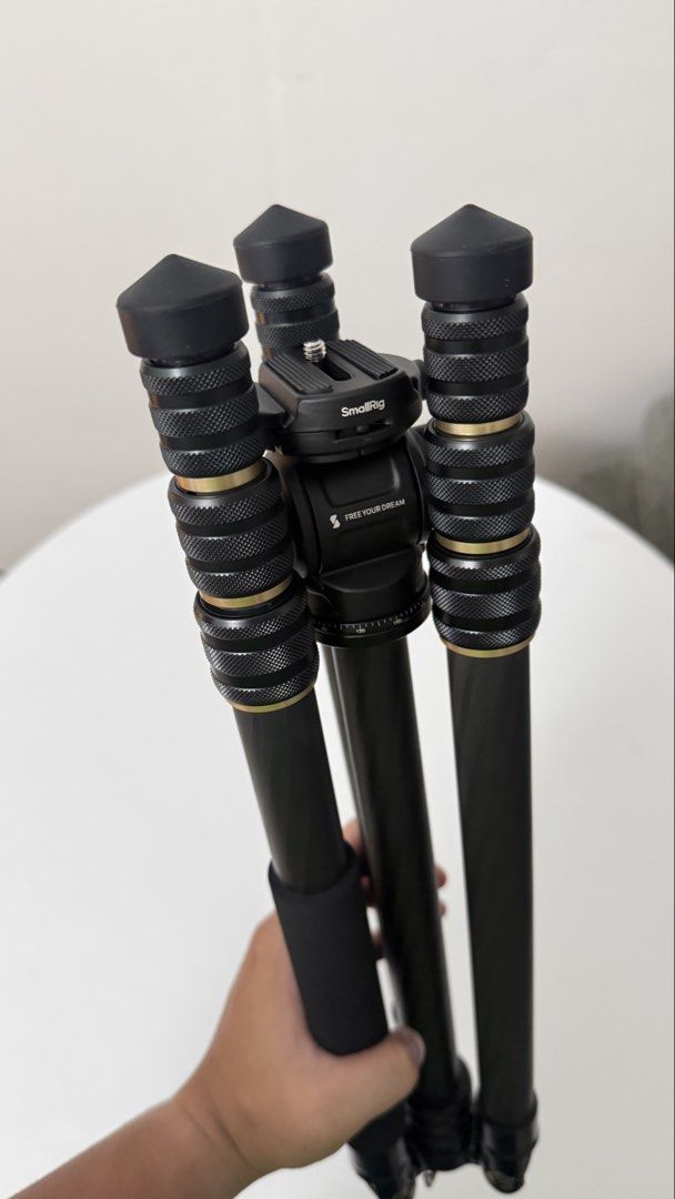 SmallRig CT150 Carbon Fiber Tripod (Category: Tripods & Monopods) located in Quezon City. Submitted by rfigueroa21 (Listing ID 1470834580, Image 2). Description: - Model: SmallRig CT254C1-CH3 Carbon Fiber Tripod with Fluid Head - Condition: Fully functional, minor scuffs on the head unit from normal use - Build: Lightweight carbon fiber with stylish gold ring accents and twist leg locks - Includes: Fluid head, pan handle, and quick release plate 