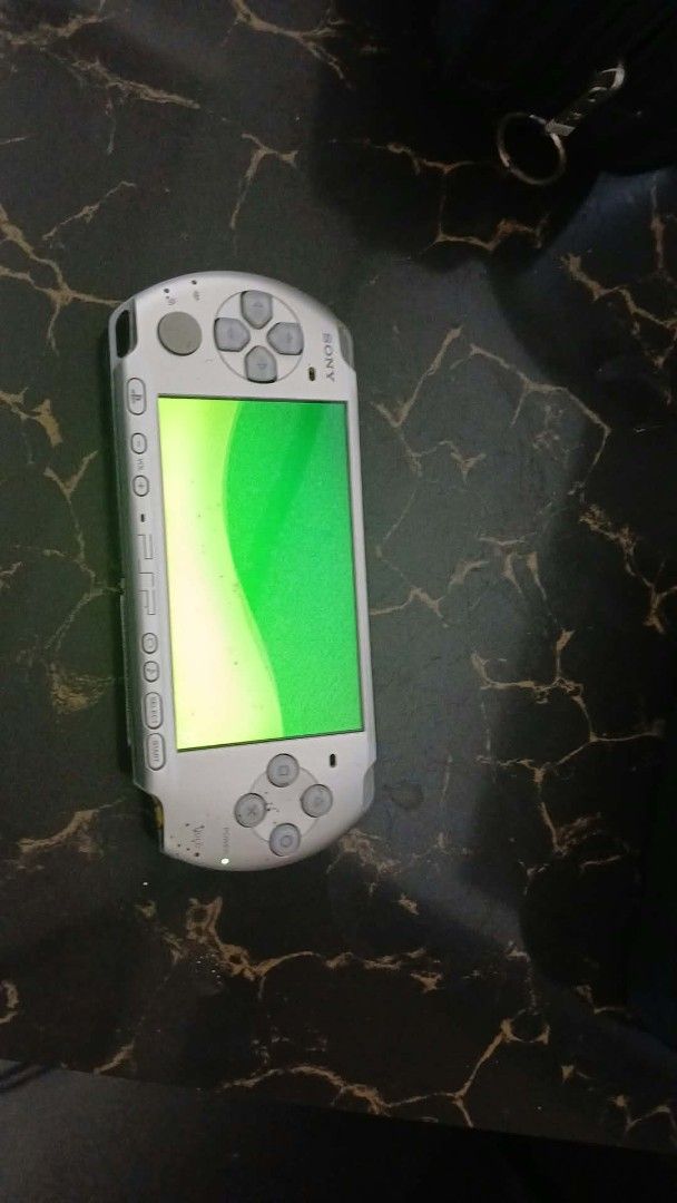 Sony PSP Silver Handheld Console with Games and Charger (Category: PlayStation) located in Cavite. Submitted by ambon2022 (Listing ID 1470930280, Image 3). Description: - Authentic Silver Sony PlayStation Portable (PSP) console bundle - Includes power adapter, carrying case, and a collection of UMD game discs - Fully tested: screen turns on and reads media successfully - Shows normal cosmetic wear and tear from regular use - Ideal retro gaming bu