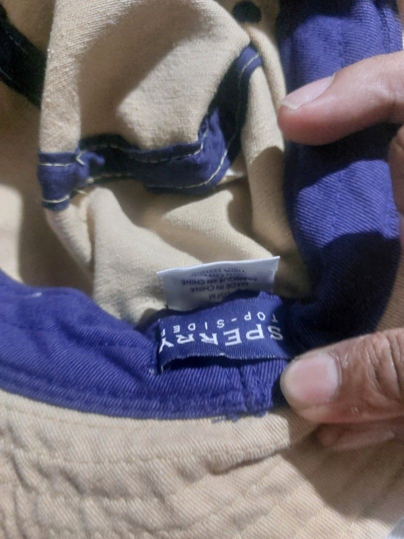 Sperry Top-Sider Beige Bucket Hat (Category: Caps & Hats) located in Magarao. Submitted by hotdogsandwich.flower (Listing ID 1470749992, Image 2). Description: - Brand: Sperry Top-Sider - Color: Tan with blue & orange stripe, contrast purple lining - Material: 100% breathable cotton - Fit: Standard fit - Details: Small logo tag on the side - Condition: Great for sunny days and outdoor wear - Origin: Made in China.