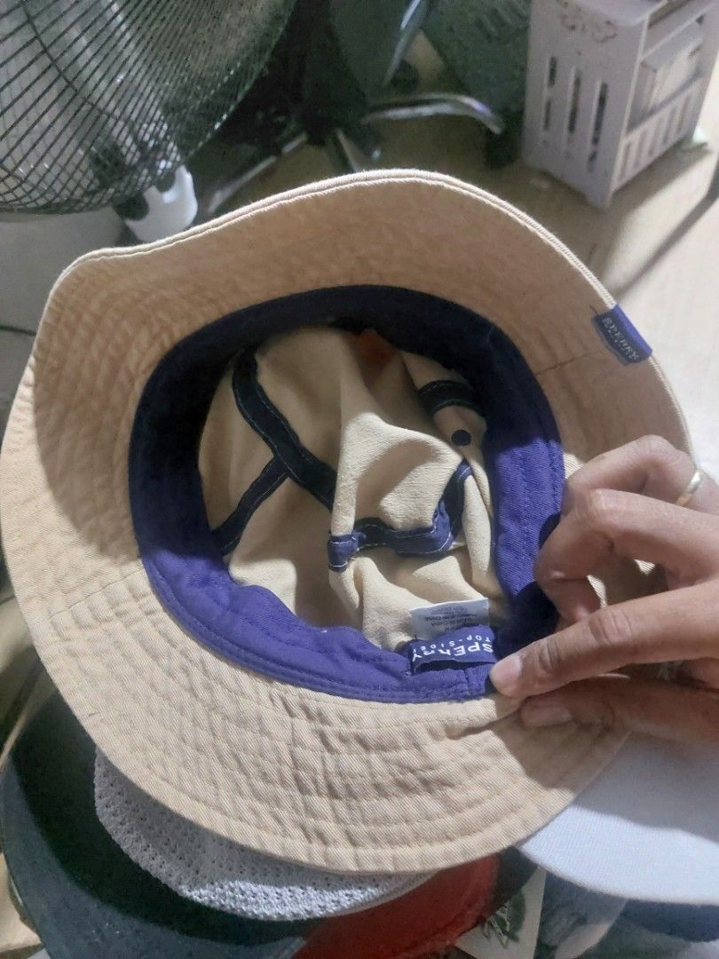 Sperry Top-Sider Beige Bucket Hat (Category: Caps & Hats) located in Magarao. Submitted by hotdogsandwich.flower (Listing ID 1470749992, Image 3). Description: - Brand: Sperry Top-Sider - Color: Tan with blue & orange stripe, contrast purple lining - Material: 100% breathable cotton - Fit: Standard fit - Details: Small logo tag on the side - Condition: Great for sunny days and outdoor wear - Origin: Made in China.