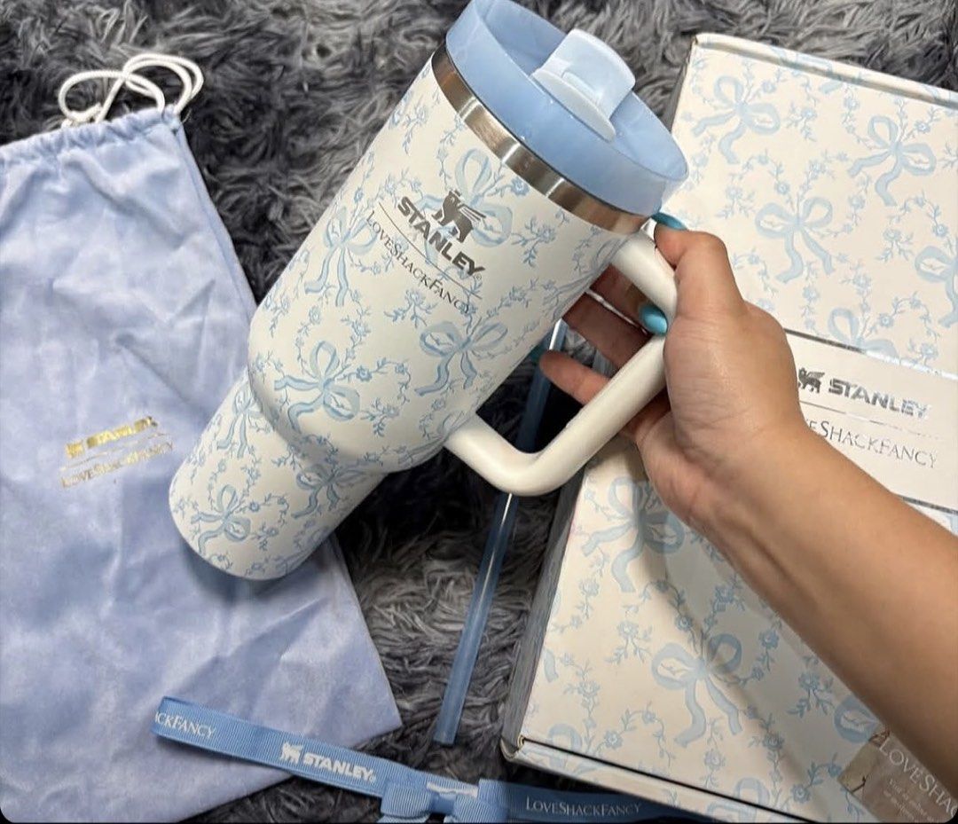 Stanley x LoveShackFancy Quencher Tumbler (Category: Water Bottles & Tumblers) located in Manila. Submitted by sansairo (Listing ID 1470872707, Image 1). Description: - Authentic Stanley x LoveShackFancy Collaboration - Design: Blue floral bow print - Condition: Brand new, never used - Complete set includes: Matching box, dust bag, ribbon, and straw - Features: Large side handle and screw-on lid with straw opening.