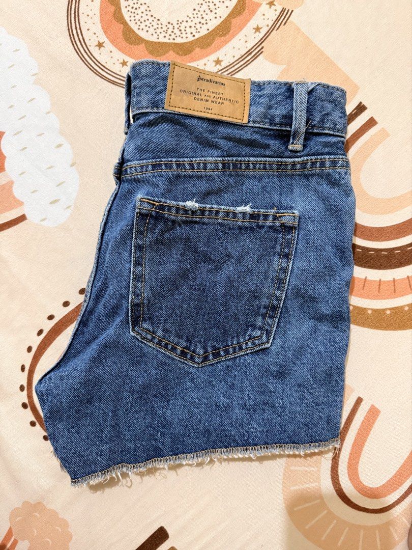 Stradivarius Denim Shorts Raw Hem Medium Wash (Category: Shorts) located in Quezon City. Submitted by earlyyy0729 (Listing ID 1470903240, Image 2). Description: -Size 25-26 - Brand: Stradivarius - Style: High-waisted denim shorts - Wash: Medium blue - Details: Raw hem, pocket distressing, contrast stitching, and brand patch - Condition: Excellent staple piece.