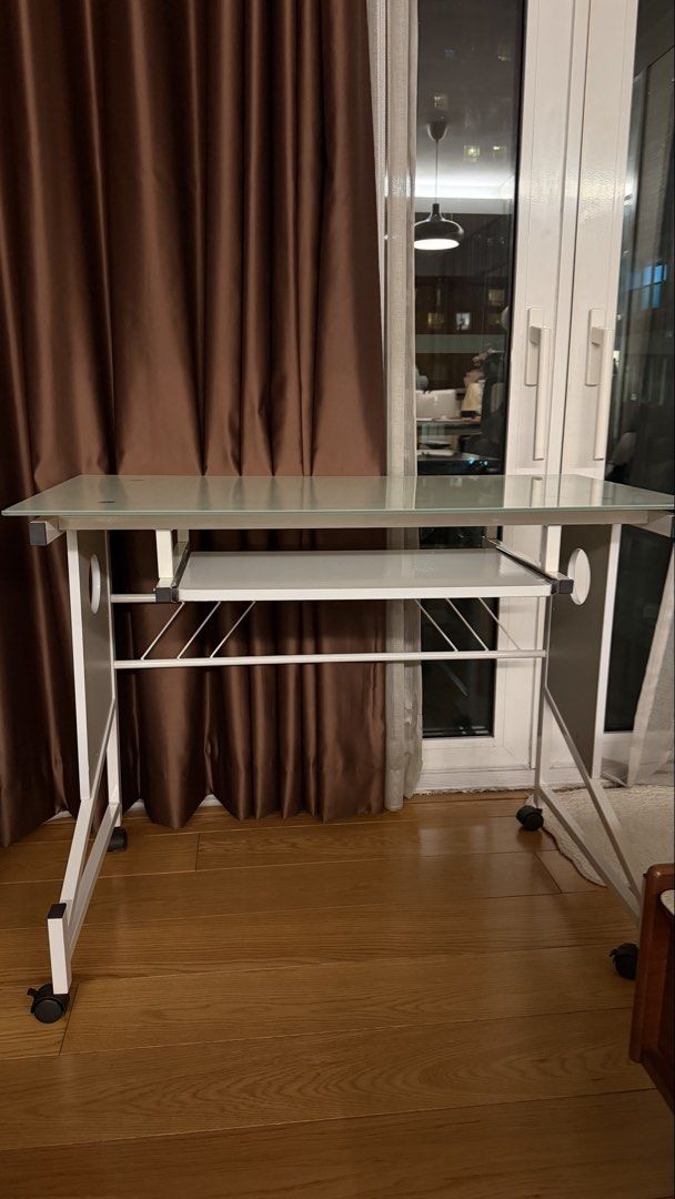 Study Table (Category: Tables & Sets) located in Makati City. Submitted by shopbb (Listing ID 1470877650, Image 1). Description: - Modern tempered glass top computer desk - Convenient pull-out keyboard shelf - Sturdy white metal frame with locking castor wheels for easy mobility - Built-in wire management holes on side panels to keep cords neat - Standard workstation size, ideal for any home office or study space.