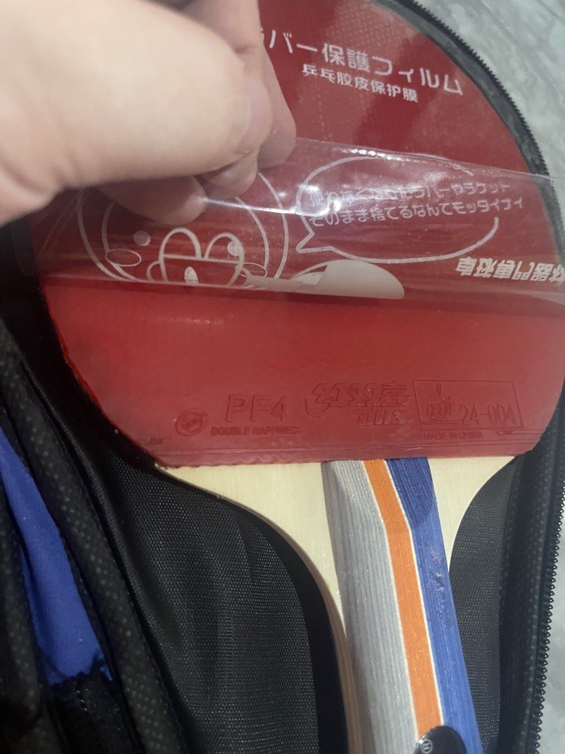 SUPER-K DHS PF4 Table Tennis Racket With Case And Balls (Category: Racket and Ball Sports) located in Caloocan City. Submitted by beans97 (Listing ID 1470782868, Image 3). Description: - Brand/Model: SUPER-K table tennis racket - Rubbers: DHS PF4 rubber on both sides with protective films included - Handle: Wooden handle with trendy grey, orange, and blue stripes - Accessories: Includes a blue carrying case with a black star design and multiple o