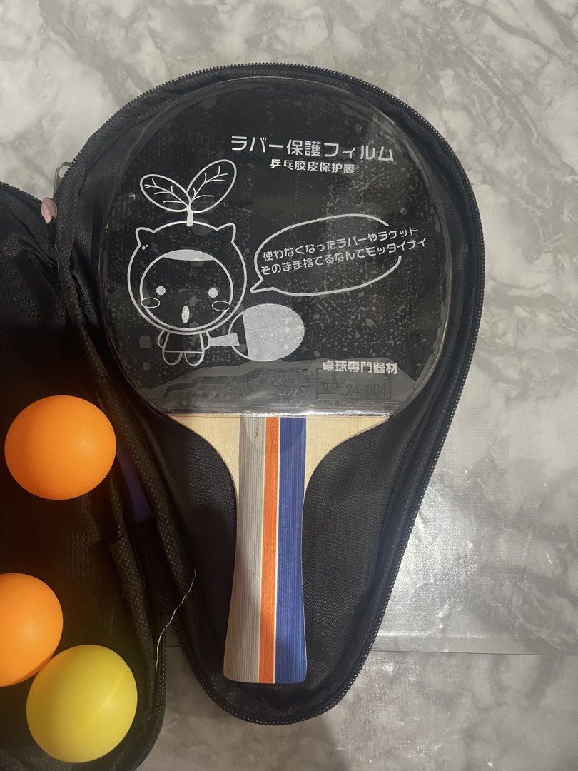 SUPER-K DHS PF4 Table Tennis Racket With Case And Balls (Category: Racket and Ball Sports) located in Caloocan City. Submitted by beans97 (Listing ID 1470782868, Image 2). Description: - Brand/Model: SUPER-K table tennis racket - Rubbers: DHS PF4 rubber on both sides with protective films included - Handle: Wooden handle with trendy grey, orange, and blue stripes - Accessories: Includes a blue carrying case with a black star design and multiple o