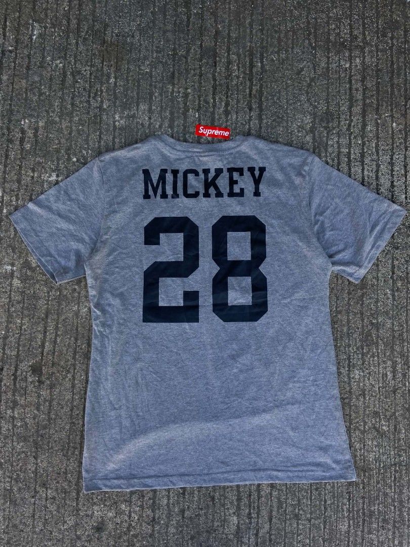 Supreme Mickey Mouse Graphic Tee Gray XL (Category: Tshirts & Polo Shirts ) located in Lianga. Submitted by arwthrifts (Listing ID 1470843952, Image 2). Description: - Authentic Supreme Mickey Mouse graphic tee - Color: Heather Gray - Size: XL - Front features a classic Mickey image on a blue background - Back features "MICKEY" and "28" printed in black - Material: 100% pre-shrunk cotton, made in USA - Condition: Brand new with red swing tag atta