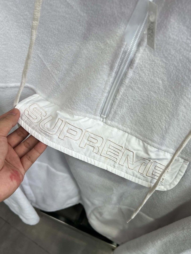 Supreme White Fleece Half-Zip Hoodie (Category: Coats, Jackets and Outerwear) located in Urdaneta. Submitted by jayceegarage (Listing ID 1470880687, Image 2). Description: - Brand: Supreme - Style: White fleece half-zip hoodie - Material: Cozy, warm fleece - Features: Quarter-zip neck, drawstring hood, adjustable fit - Pocket: Front pouch pocket with embroidered Supreme lettering on the flap - Condition: Clean white colorway, tagged inside collar