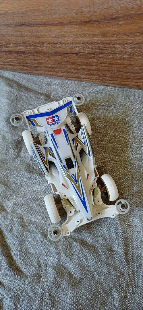 Tamiya Mini 4WD MS-L Chassis White (Category: Vehicle & Diecast Models) located in Baybay. Submitted by buhatsakahoy (Listing ID 1470793329, Image 2). Description: - Chassis: MS-L (with T-01 and N-02 bottom markings) - Body: White with neat blue, gold, and white decals - Wheels/Rollers: White wheels with gray front and rear rollers - Condition: Clean build with precisely applied stickers on the wing and side cowls.