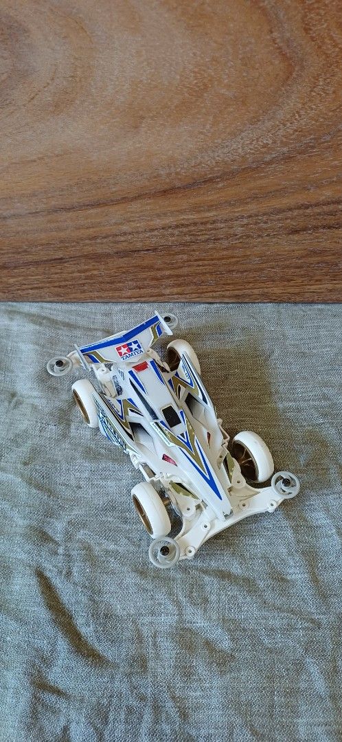 Tamiya Mini 4WD MS-L Chassis White (Category: Vehicle & Diecast Models) located in Baybay. Submitted by buhatsakahoy (Listing ID 1470793329, Image 1). Description: - Chassis: MS-L (with T-01 and N-02 bottom markings) - Body: White with neat blue, gold, and white decals - Wheels/Rollers: White wheels with gray front and rear rollers - Condition: Clean build with precisely applied stickers on the wing and side cowls.