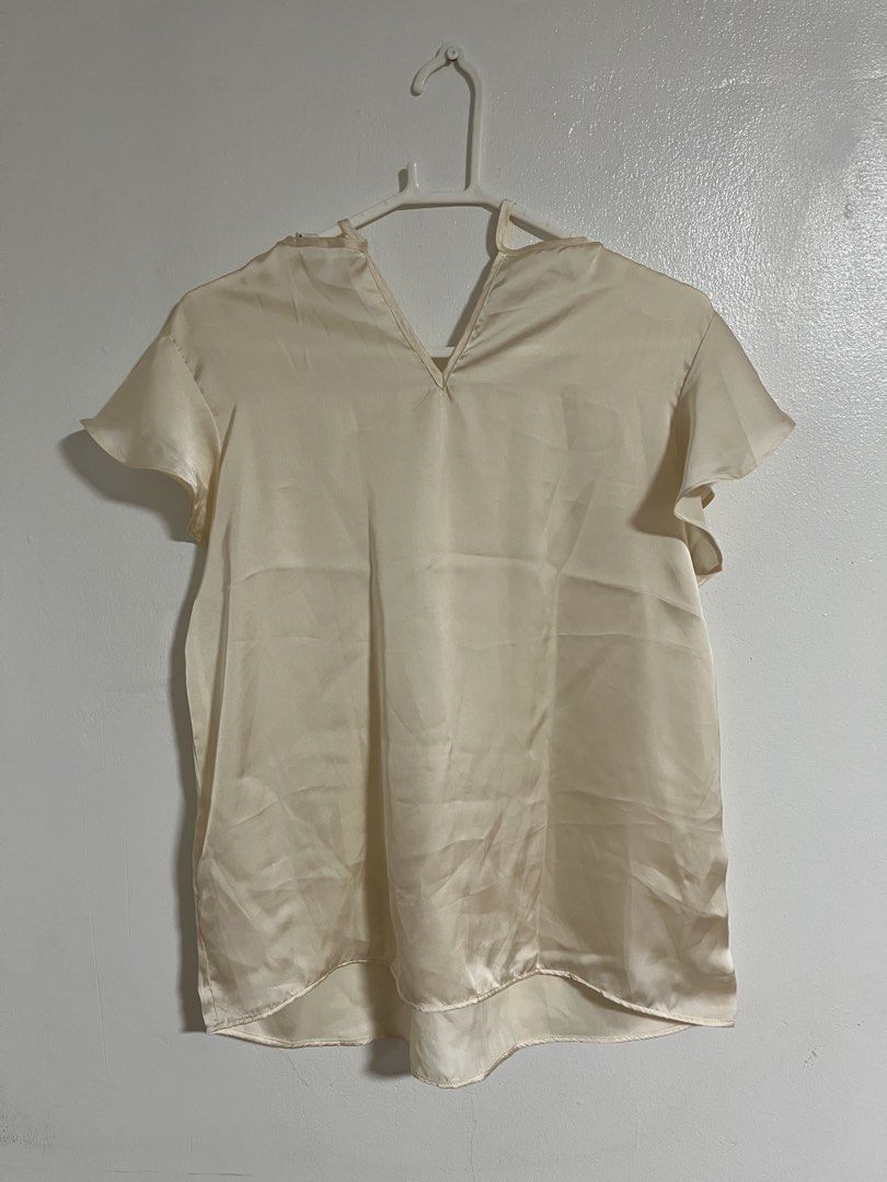 Terranova Cream Satin Ruffle Sleeve Blouse (Category: Blouses) located in Cabuyao City. Submitted by rdtrmt (Listing ID 1470744142, Image 1). Description: - Brand: Terranova - Size: L - Material: Smooth satin with a subtle sheen - Design: V-neckline with collar tie strings and short ruffle sleeves - Fit: Relaxed fit through the body - Versatility: Perfect for casual wear or office outfits - Condition: Clean overall, still in good condition.