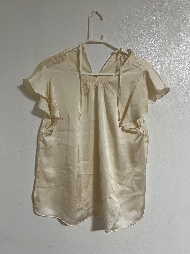Terranova Cream Satin Ruffle Sleeve Blouse (Category: Blouses) located in Cabuyao City. Submitted by rdtrmt (Listing ID 1470744142, Image 3). Description: - Brand: Terranova - Size: L - Material: Smooth satin with a subtle sheen - Design: V-neckline with collar tie strings and short ruffle sleeves - Fit: Relaxed fit through the body - Versatility: Perfect for casual wear or office outfits - Condition: Clean overall, still in good condition.