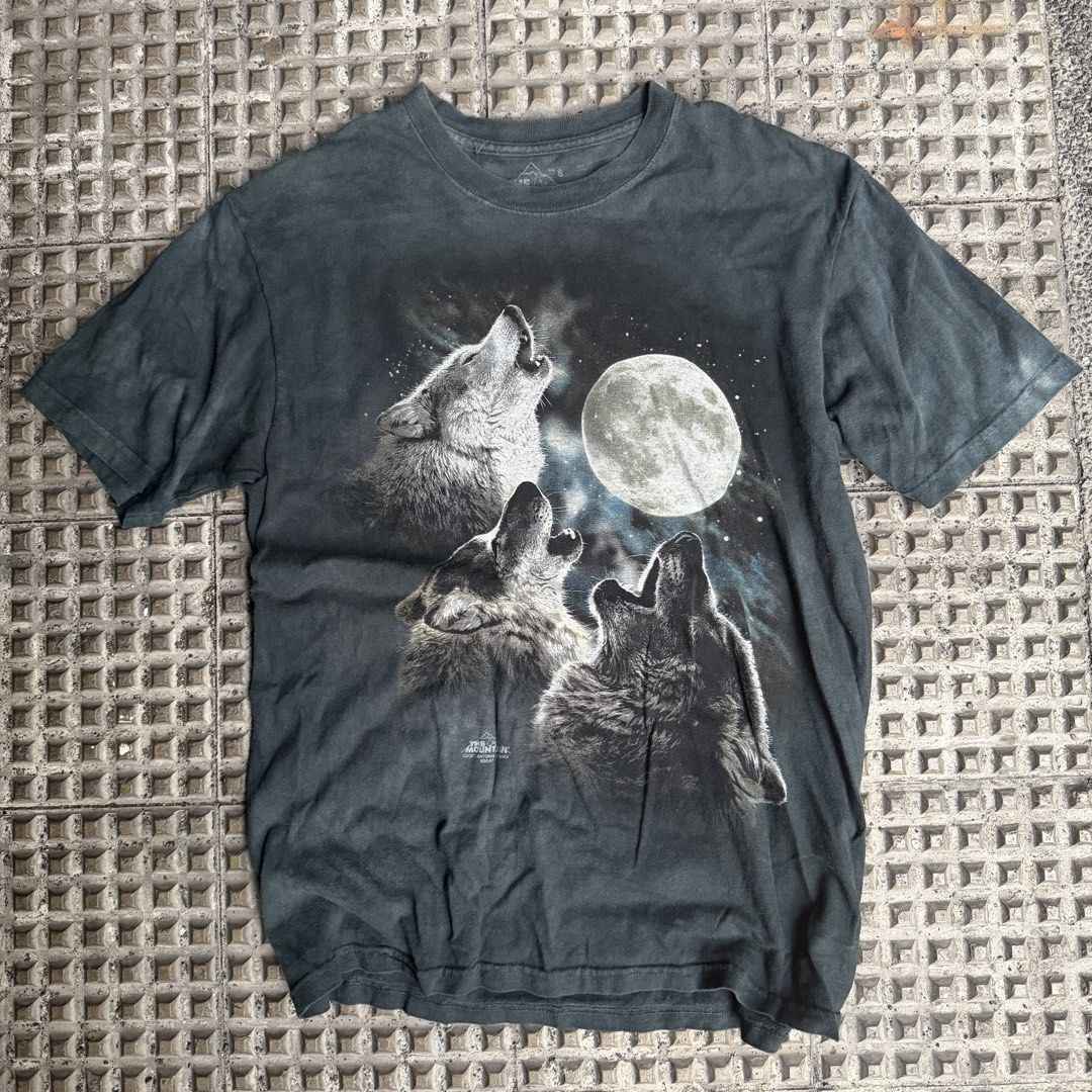 The Mountain Three Wolves Moon Graphic T-Shirt (Category: Tshirts & Polo Shirts ) located in Manila. Submitted by marx_g (Listing ID 1470831186, Image 1). Description: - Brand: The Mountain - Design: Large wolf pack howling at the full moon graphic - Color/Finish: Dark gray with a vintage worn-in wash fade - Size: Small - Material: Comfortable cotton - Style: Classic crew neck, short sleeves - Perfect for retro animal tee collectors.
