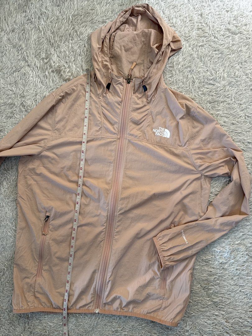 The North Face WindWall Pink Windbreaker Jacket (Category: Coats, Jackets and Outerwear) located in Quezon City. Submitted by dropdeadprices (Listing ID 1470785804, Image 3). Description: - Brand: The North Face - Style: Unisex WindWall Hooded Jacket - Color: Peach Pink - Features: Full zip closure, secure zipped hand pockets, adjustable hood drawstrings, WindWall wind-blocking technology - Material: 100% nylon shell - Size on Tag: US Men's M/L /
