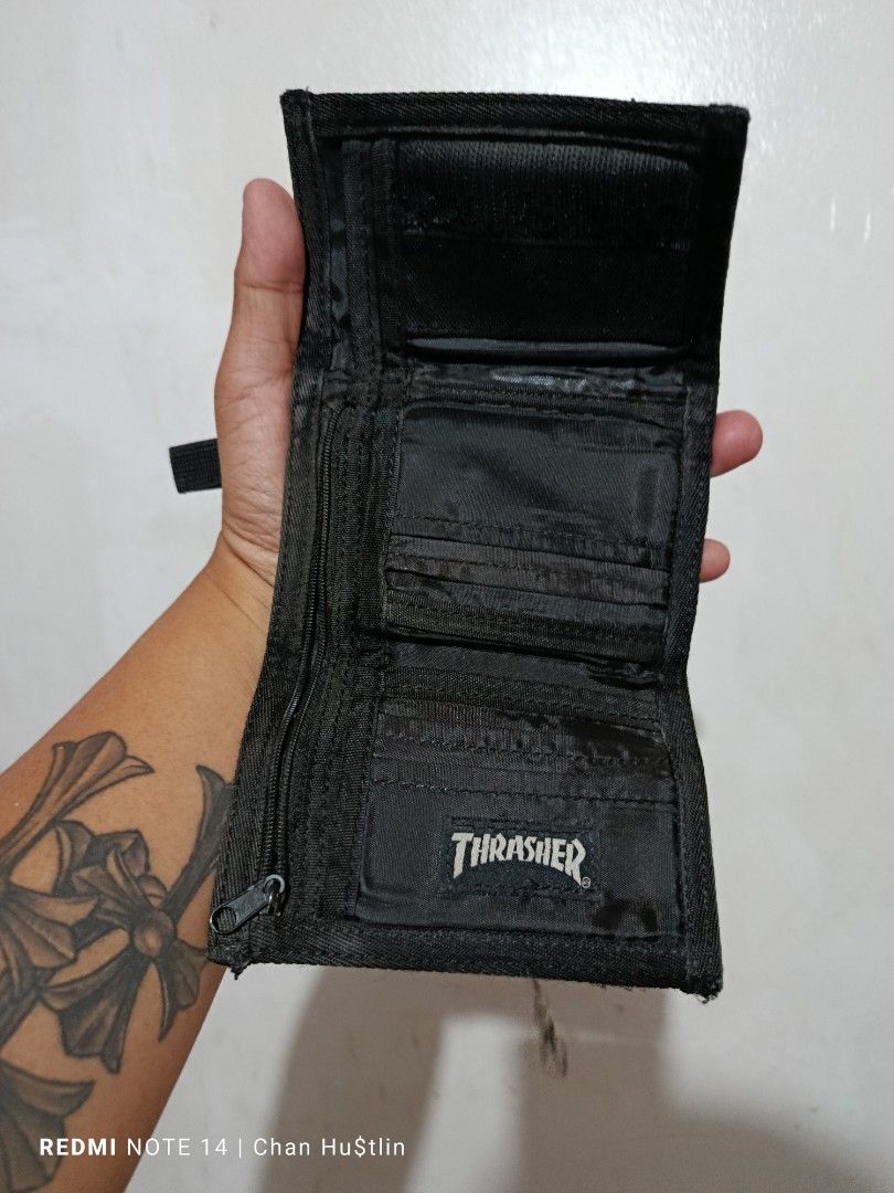 Thrasher Black Tri-fold Vintage Wallet with Chain (Category: Wallets & Card Holders) located in Calamba. Submitted by chanmagpantay (Listing ID 1470754196, Image 3). Description: - Brand: Thrasher - Color/Material: Black canvas - Type: Tri-fold wallet - Storage: Outer zipper pocket, multiple interior card slots, and cash compartments - Extras: Attached metal chain and loop strap included - Condition: Brand new / Excellent quality skate accessory.