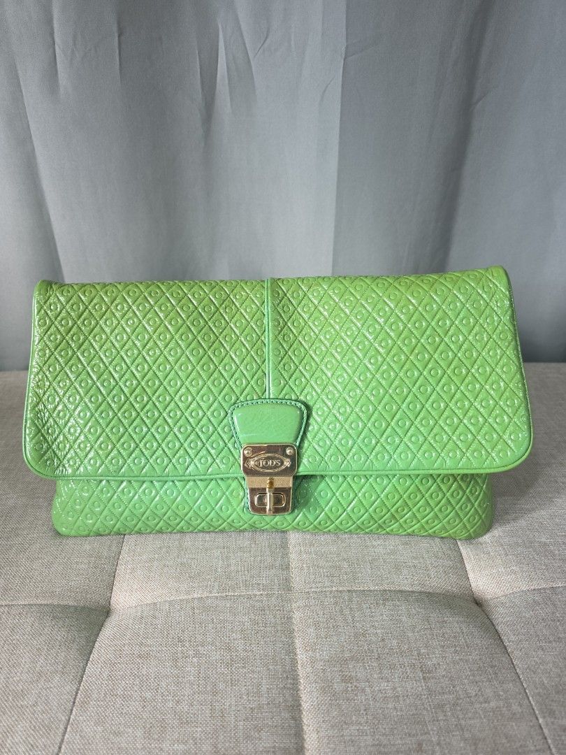 Tod's Signature Patent Leather (Category: Luxury Bags & Wallets) located in Binan City. Submitted by karosellescloset (Listing ID 1470753312, Image 1). Description: Tod's Signature Patent Leather Clutch (or flap bag) in green. ​Key Details: ​Design Feature: Features the iconic 3D embossed Gommino pebble / diamond geometric motif across the patent leather exterior, inspired by the raised rubber studs on Tod's signature driving shoes. ​Hardware: Go