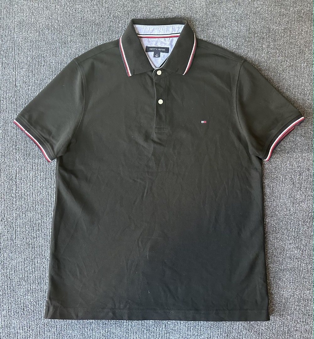 Tommy Hilfiger (Category: Tshirts & Polo Shirts ) located in Imus. Submitted by alecsssss (Listing ID 1470770408, Image 1). Description: - Brand: Tommy Hilfiger - Color: Black - Size: Medium - Details: Classic collar with red, white, and blue tipping; two-button placket; small embroidered logo on left chest - Style: Short sleeve, versatile for casual outfits - Condition: 7/10 - May punit sa isang manggas.