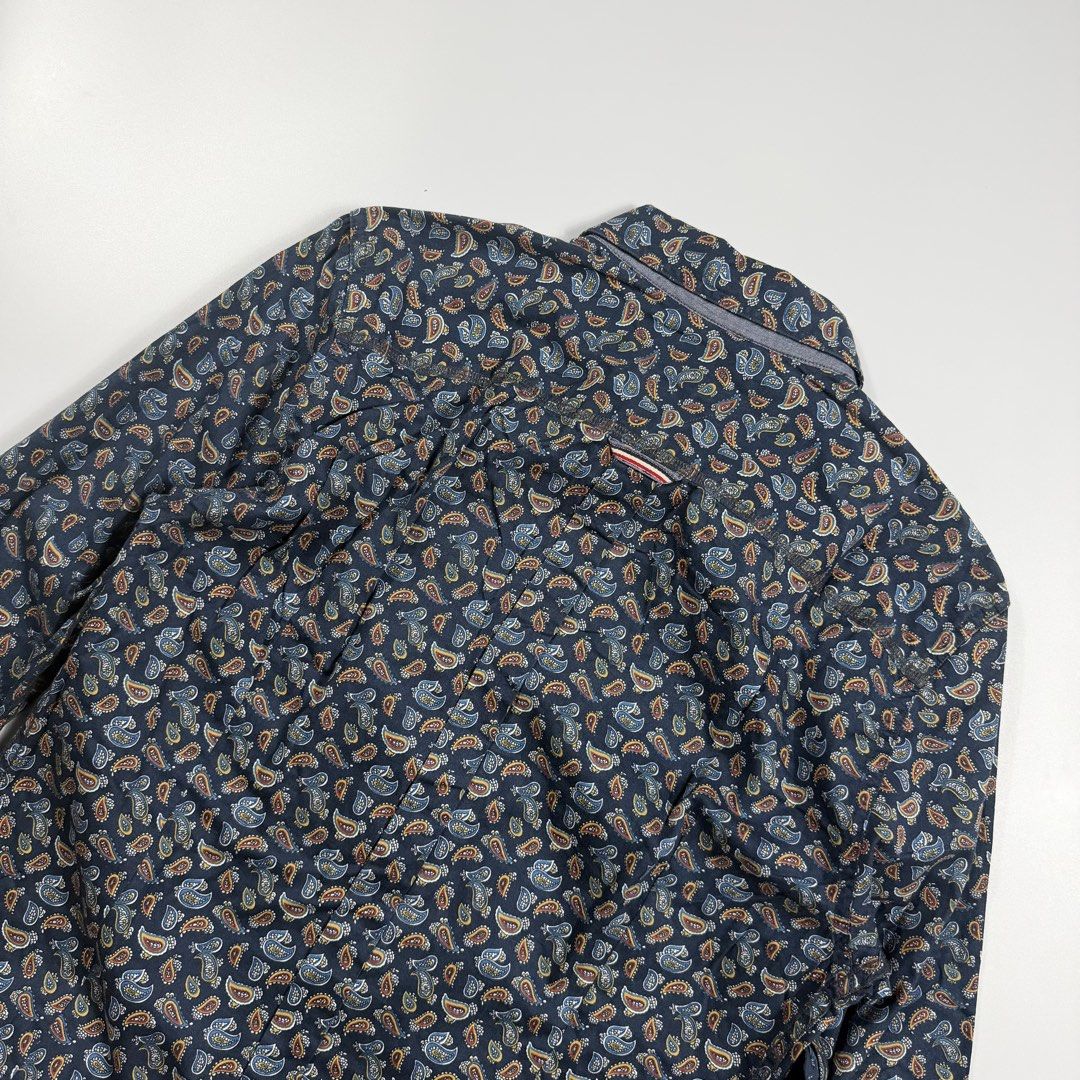 Tommy Hilfiger Denim Paisley (Category: Formal Shirts) located in Bacolod City. Submitted by freshstuff13 (Listing ID 1470928118, Image 3). Description: - Brand: Hilfiger Denim - Size: Small (Slim Fit) - Color/Pattern: Dark blue base with a multi-color all-over paisley design - Features: Button-down front with dark buttons, single chest pocket with a tiny flag logo tag, and a curved hemline - Condition: Excellent pre-loved condition - Perfect for