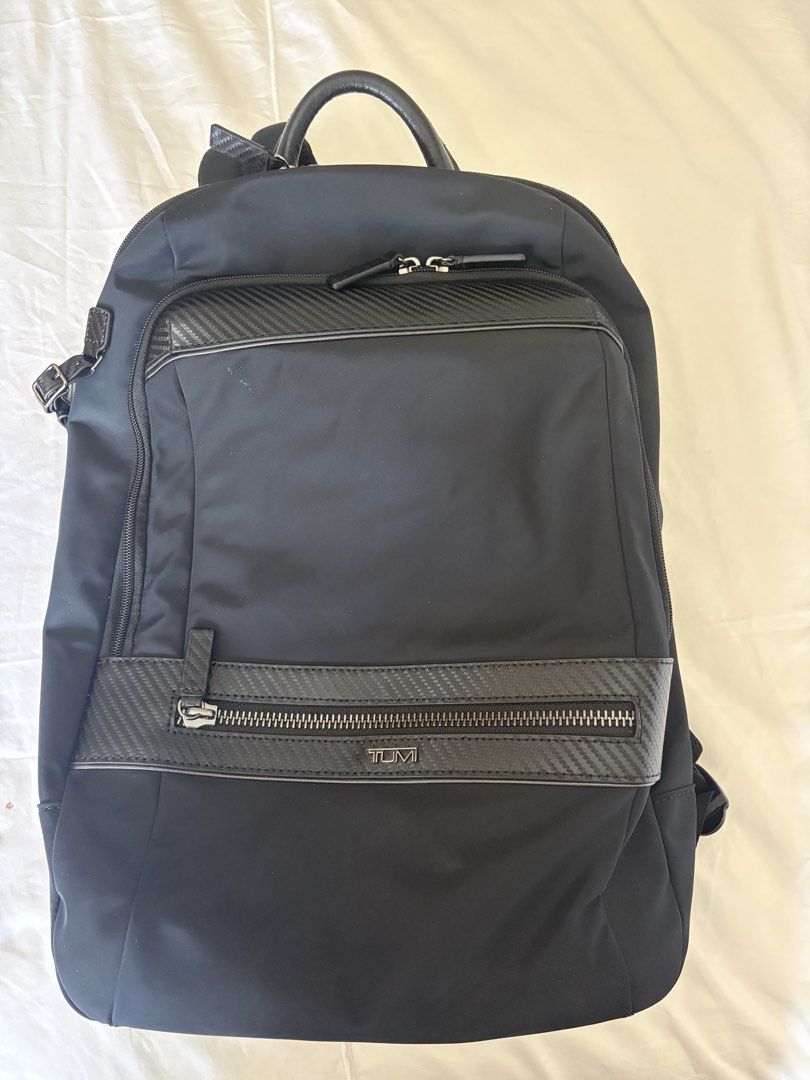 TUMI Black Backpack with Carbon Fiber Accents (Category: Backpacks) located in Taguig. Submitted by gurgeh50 (Listing ID 1470757727, Image 1). Description: - Authentic black TUMI backpack with sleek carbon fiber patterned trim - Durable nylon construction ideal for daily commute, work, or travel - Spacious main compartment with a padded laptop sleeve and secure zipper pocket - Front organizer section with dedicated slots for cards, pens, and esse