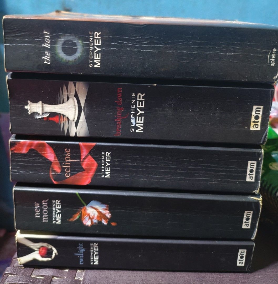 Twilight Saga 5-Book Collection by Stephenie Meyer (Category: Storybooks) located in Manila. Submitted by dreamy_collections (Listing ID 1470896148, Image 1). Description: - Complete Twilight Saga set: Twilight, New Moon, Eclipse, and Breaking Dawn - Bonus book included: The Host - Paperback editions published by Atom and Sphere - Condition: Shows yellowing and aging from previous reads, adding a vintage charm - Perfect bundle for fans and book c