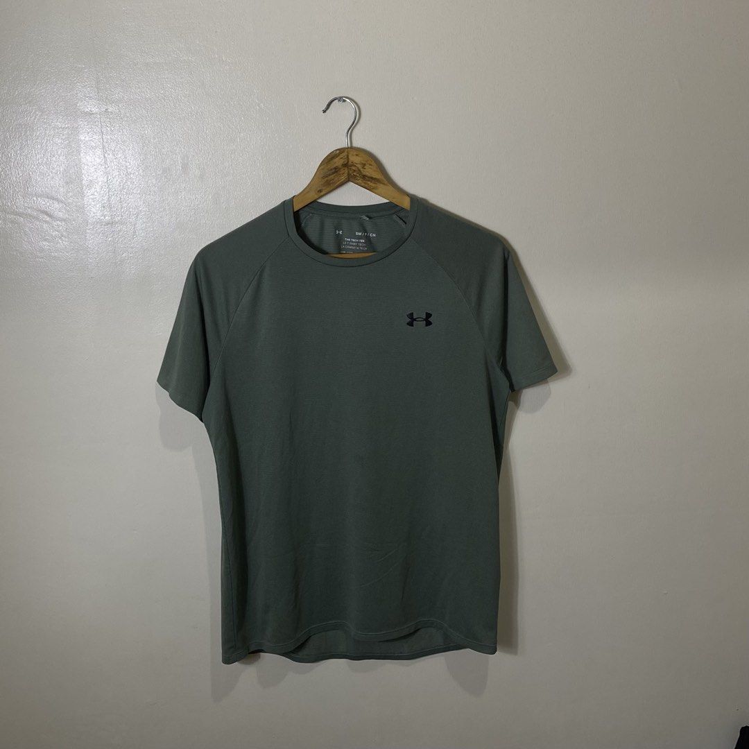Under Armour Tech Tee Olive Green (Category: Activewear) located in Cebu City. Submitted by theloose.thread (Listing ID 1470918495, Image 1). Description: - Brand: Under Armour - Item: Tech Tee / Workout Shirt - Color: Olive Green - Size: Small - Fit: Loose fit with short raglan sleeves - Material: Lightweight, super breathable polyester - Details: Small UA logo on chest and back neck - Condition: Great for gym, running, and activewear.