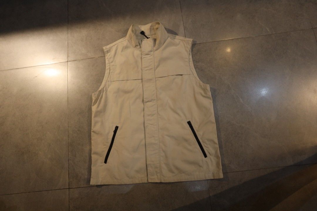 Uniqlo Beige Utility Vest (Category: Vests) located in Manila. Submitted by krzxyprk (Listing ID 1470771431, Image 2). Description: - Brand: Uniqlo - Item: Utility Vest - Color: Beige - Closure: Front zipper hidden under a button placket - Collar: Stand collar - Pockets: Two zippered slant pockets on the lower front - Material: Lightweight cotton blend - Style: Great for layering over tees or long sleeves.