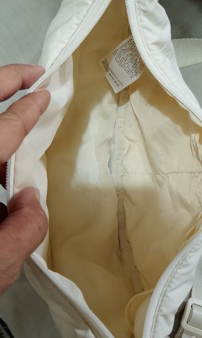 UNIQLO Cross bodybag (Category: Cross-body Bags) located in Tarlac. Submitted by faithfulfinds (Listing ID 1470841914, Image 2). Description: Crescent / Half Moon Nylon Shoulder Bag UNIQLO Condition: Lightly used Details: Has minimal, unnoticeable signs of use but still in good condition. Note: There are some small lints/runs (please check photos for a closer look, but they don't affect the overall use and look of the bag). Color: Off-white Style