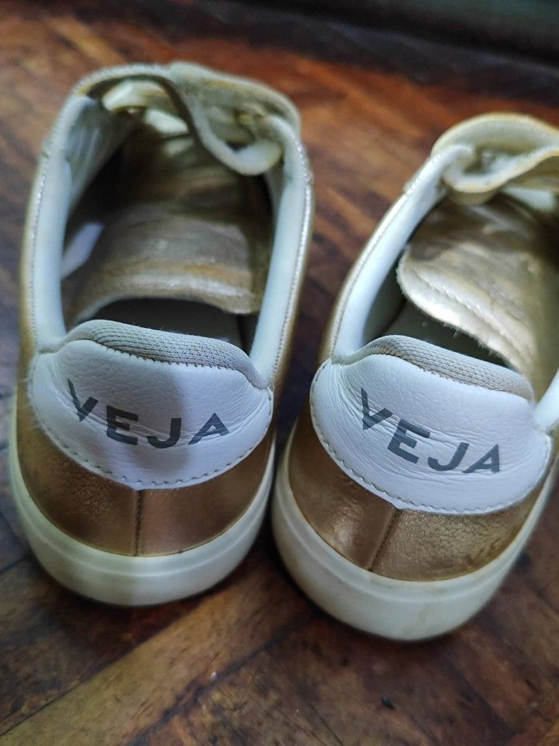 Veja Metallic Gold Velcro Sneakers (Category: Sneakers) located in Bacoor. Submitted by stargazer1084 (Listing ID 1470835822, Image 3). Description: - Brand: Veja - Material: Metallic gold leather with white rubber sole - Style: Triple velcro strap closure with bold VEJA logo branding - Condition: Noticeable wear and dirt buildup on velcro straps; minor scuffs on soles from previous use - Perfect for adding a shiny pop to your everyday casual fit