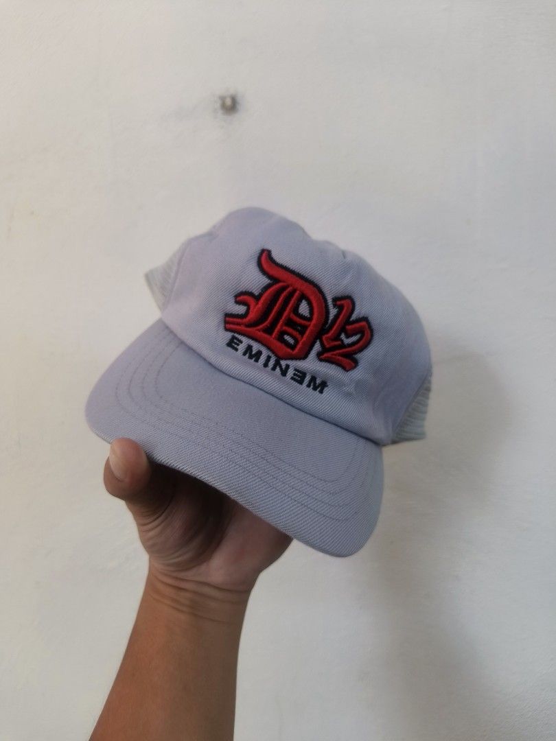 Vintage Eminem D12 Trucker Hat Grey Snapback Cap (Category: Caps & Hats) located in Bacolod City. Submitted by jimar4955 (Listing ID 1470766945, Image 1). Description: - Vintage grey trucker hat with mesh back - Front embroidered Eminem and D12 logo in red and black - Adjustable snapback closure - Made in Korea - Material: 80% acrylic, 20% wool blend - Condition: Structurally solid with minor yellowing and sweat staining on the inner forehead ban