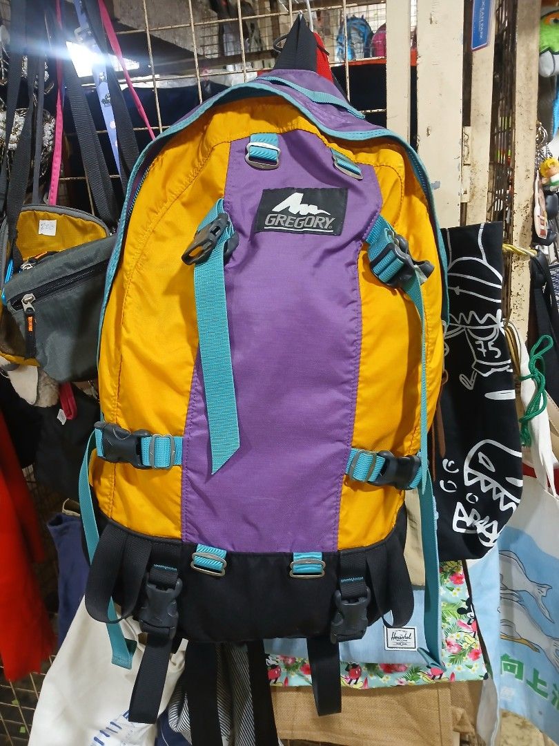 Vintage Gregory Multicolor Backpack Made in USA (Category: Backpacks) located in Manila. Submitted by zackthrift16 (Listing ID 1470887346, Image 1). Description: - Authentic vintage Gregory backpack in a vibrant yellow, purple, and teal colorway - Classic woven brand patch stitched on the front - Heavy-duty zippers with smooth metal pulls - Features the iconic American flag interior tag - Spacious main compartment with plenty of storage space - A