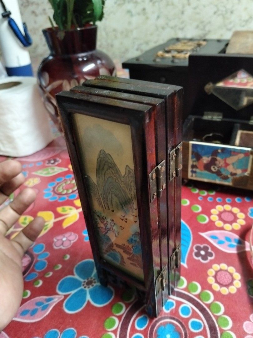 Vintage Mini Four-Panel Wooden Table Screen Asian Art (Category: Vintage Collectibles) located in Abucay. Submitted by cristineca20489 (Listing ID 1470916146, Image 3). Description: - Type: Miniature four-panel tabletop room divider - Material: Dark wood frames with durable metal hinges - Design: Reversible; one side features painted birds on floral branches, reverse side shows a traditional mountain landscape - Features: Fully foldable for easy 
