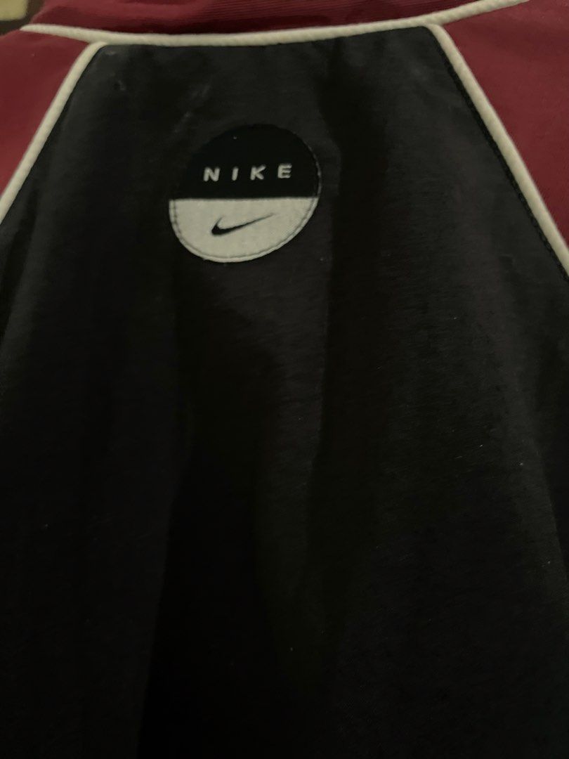 Vintage Nike Maroon Black Windbreaker Jacket Size M (Category: Coats, Jackets and Outerwear) located in Nampicuan. Submitted by aireann_10 (Listing ID 1470860388, Image 3). Description: - Brand: Nike - Style: Colorblock windbreaker (maroon and black) - Size: Medium - Details: Full zip front, high collar, white piping accents, and two zippered side pockets - Branding: Embroidered Nike logo on chest and round graphic patch on upper back - Origin: M