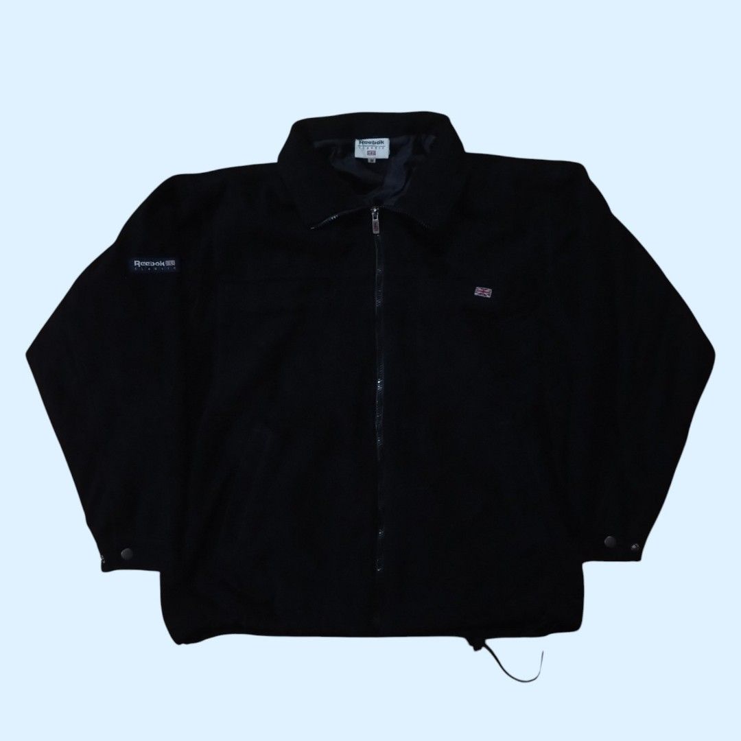 Vintage Reebok Classic Black Fleece Jacket (Category: Coats, Jackets and Outerwear) located in Tayabas. Submitted by jthriftshop. (Listing ID 1470859679, Image 1). Description: - Brand: Reebok Classic - Size: Men's Medium - Color: Black - Material: Fleece with inner lining (great for layering) - Features: Full zip closure with collar, Reebok Classic patch on right sleeve, Union Jack embroidery on left chest, and Union Jack zipper pull - Condition