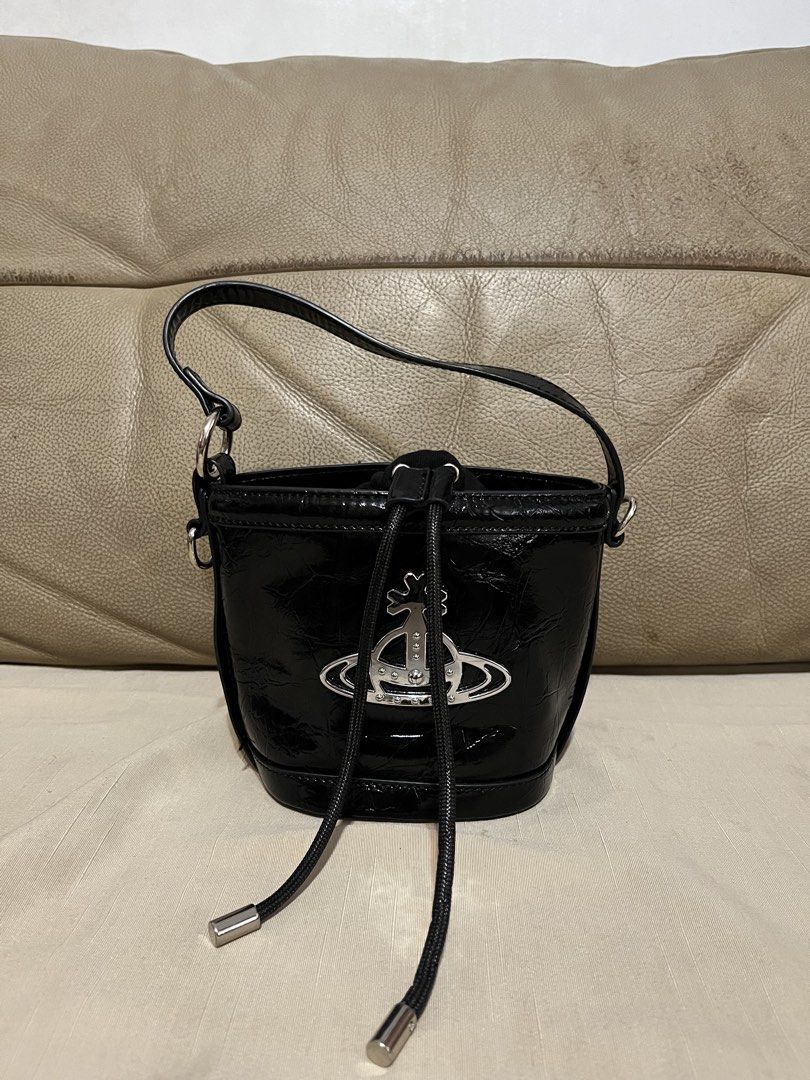 Vivienne Westwood Bucket Bag (Category: Luxury Bags & Wallets) located in Calamba. Submitted by jupreloved_ (Listing ID 1470793057, Image 3). Description: Features shiny silver hardware, iconic large metal orb logo, secure drawstring fabric interior, short handle, and long adjustable strap. Brand: Vivien Westwood Size: Small Shipping through J&T. Payment are strictly through GCASH only, no COD. Exact size and color may be different from the pictu